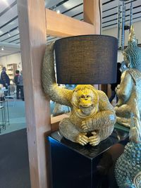 Lampe Gorilla sitzend antik-gold 36x48cm aus Kunststein gefertigt und mit schwarz-goldenem Stoffschirm kombiniert